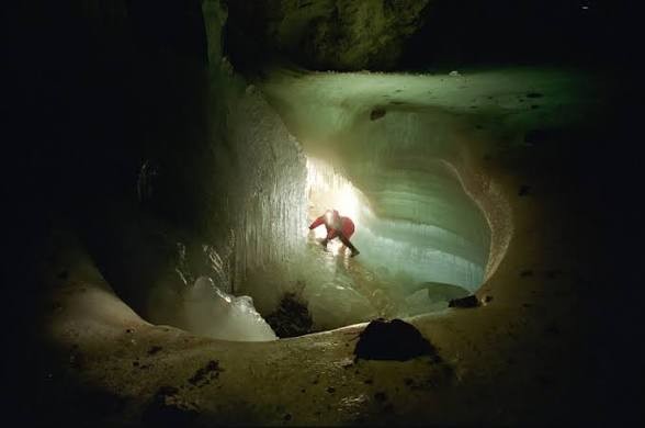 Illuminated interior of a cave with a visitor